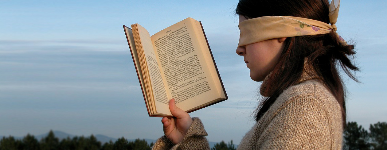 Girl reading a book blindfolded